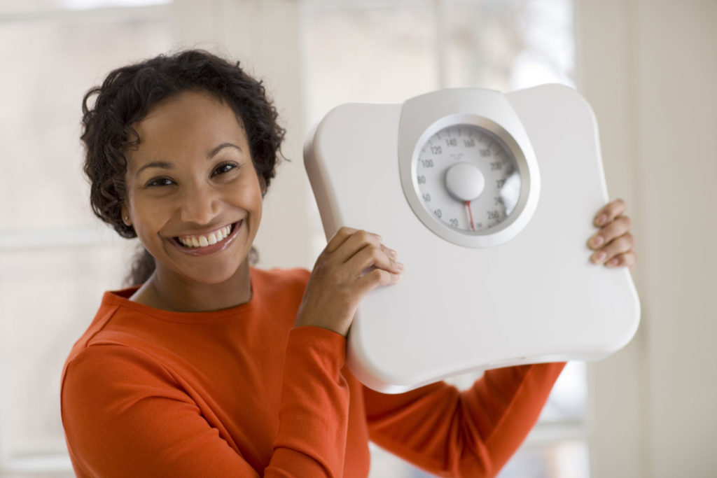 Smiling woman holding a scale